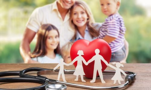 Family paper silhouette and stethoscope on wooden desk